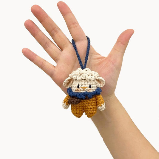 Handmade knitted sheep keychain with vibrant orange and blue accents.